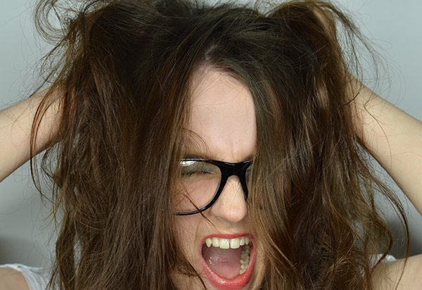 Verzweifelte Frau rauft sich die Haare, Symbolbild für PC-Probleme